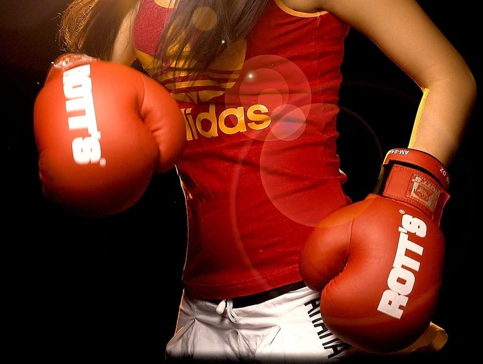 Frau mit roten Boxhandschuhen, bereit für den Kampf - Vollmond in Widder am 13.10.19