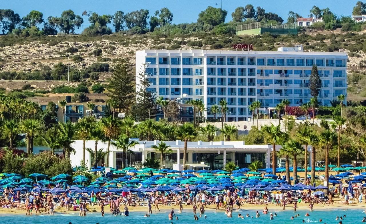 Hotel am Strand, der mit Menschen und Sonnenschirmen überfüllt ist - Finsternis im Schützen zeigt die Transformation des Tourismus