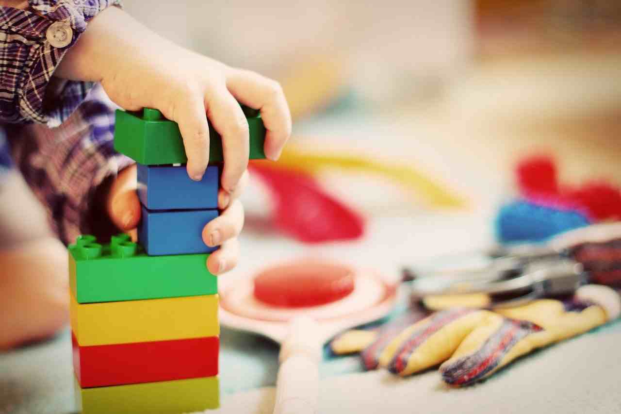 Kinderhände spielen mit Legosteinen- Saturn Uranus Quadrat Februar 2021