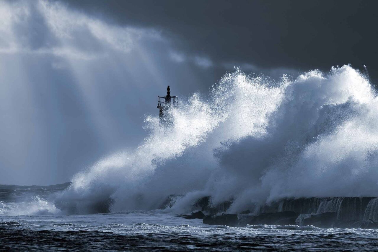 Leuchtturm und durch Sturm verursachte Wellen, die dagegen prallen - Element Luft - Jahresthemen 2022