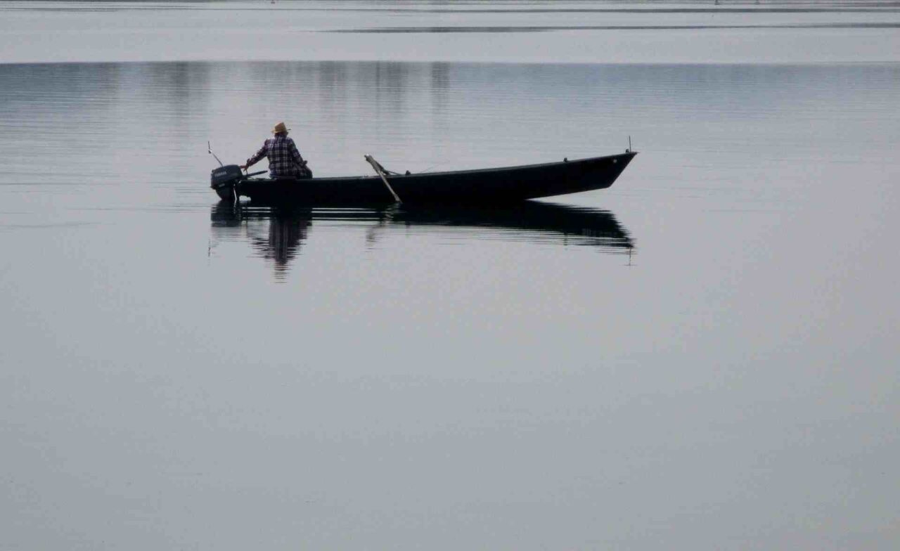 Ein Mann in einem Fischerboot auf dem Bodensee