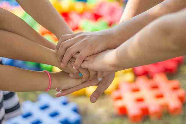 Kinderhände übereinander gelegt - Freundschaften können unter Pluto im Transit herausgefordert werden