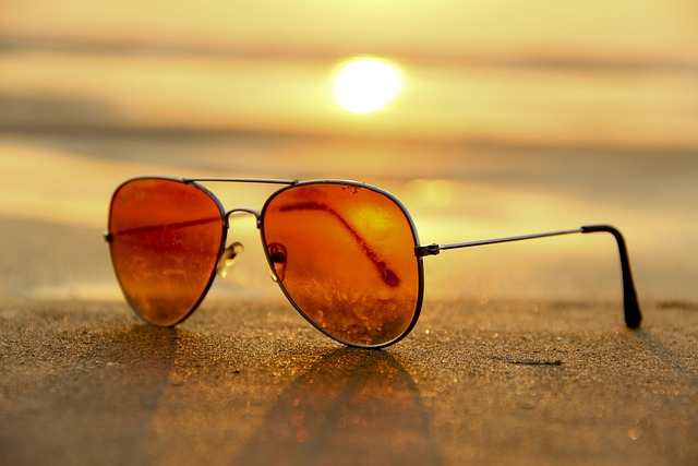 orange Sonnenbrille liegt auf dem Tisch im Sonnenuntergang - Mondknoten im Geburtshoroskop