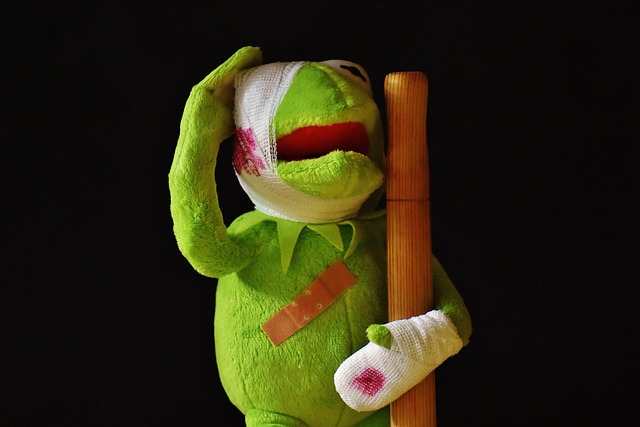 Kermit mit blutigen Verbänden um Kopf und Hand mit Gehstock - Merkur Chiron Konjunktion