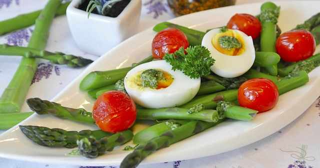 grüner Spargel und Erdbeeren, mit Eiern und kleinen Tomaten als Salat angerichtet - Vollmond im Skorpion, Stier Zeit